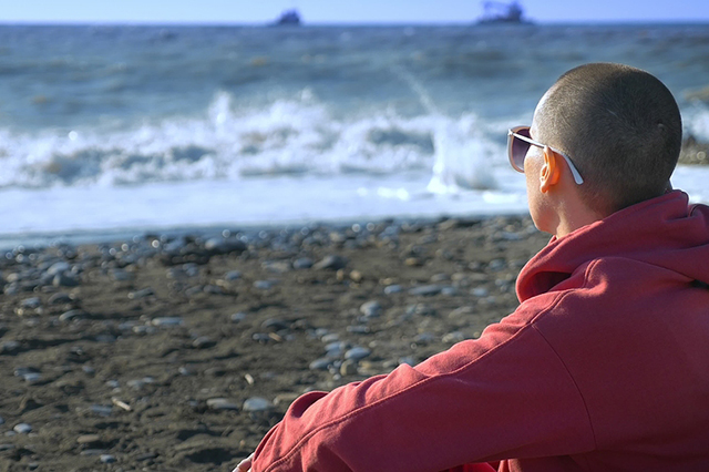 Man on berach looking at waves