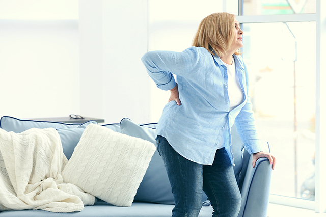 Woman with CKD holding her back